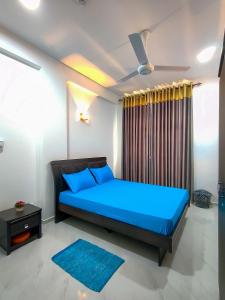 a bedroom with a blue bed and a window at Shan Stay in Moratuwa