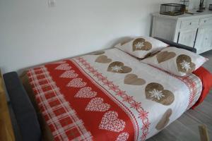 ein Bett mit einer roten und weißen Decke und Kissen in der Unterkunft Joinville : Grange entièrement rénovée style loft. in Joinville