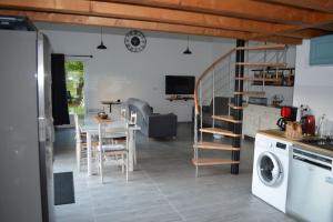 eine Küche und ein Wohnzimmer mit einem Tisch und einer Waschmaschine in der Unterkunft Joinville : Grange entièrement rénovée style loft. in Joinville