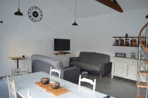 ein Wohnzimmer mit einem Tisch und einem Sofa in der Unterkunft Joinville : Grange entièrement rénovée style loft. in Joinville