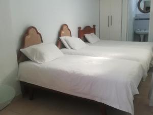 dos camas sentadas una al lado de la otra en una habitación en Gold Reef Hideout, en Johannesburgo