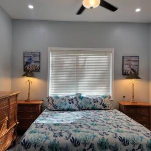 ein Schlafzimmer mit einem Bett, zwei Lampen und einem Fenster in der Unterkunft Humpback Whale - New House View of Imperial River- 1.5 Mi 2 Beach in Bonita Springs