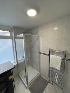 ein Badezimmer mit Dusche mit Glasduschkabine in der Unterkunft Garnet - Deluxe London Studio in South Norwood