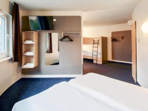 a hotel room with a bed and a mirror at B&B Hotel Würzburg in Würzburg