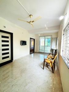 a living room with a ceiling fan and a bench at Hotel Golden Homes Inn Puri in Puri