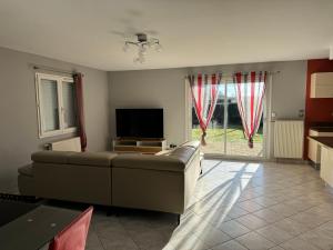 ein Wohnzimmer mit einem Sofa und einem TV in der Unterkunft Grande Maison Moderne in Beaune-les-Mines