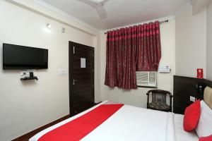 a bedroom with a bed and a flat screen tv at Hotel Relax in Gwalior