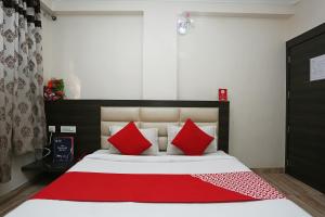 a bedroom with a large bed with red pillows at Hotel Relax in Gwalior