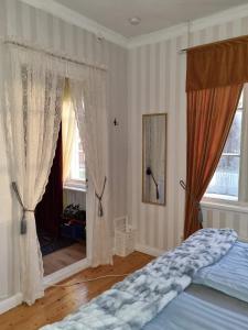a bedroom with a bed and two windows with curtains at Paradiset in Hammarland
