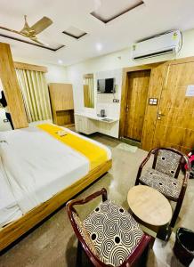 a bedroom with a bed and a table and chairs at Hotel Superhouse by Wisdom Madhav in Mathura