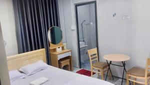 a bedroom with a bed and a mirror and a table at Hà Linh Motel in Vung Tau