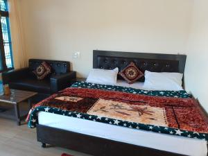 a bedroom with a bed and a couch at King of Himalaya Homestay in Sari