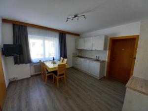 Una habitación con cocina, mesa y sillas. en Haus Jirka, en Nauders 9 fotos más