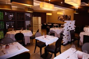 a dining room with tables and chairs with white tablecloths at Hôtel de France Vire in Vire