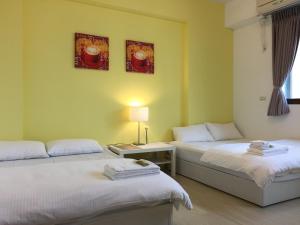 a room with two beds and a table with a lamp at STSP Guest House in Xinshi