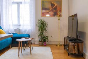 a living room with a blue couch and a tv at Plumeria - Grand 75m2 calme avec jardin - 2 Chambres - 4 Lits - Parking gratuit in Metz