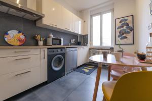 a kitchen with a washing machine and a table at Plumeria - Grand 75m2 calme avec jardin - 2 Chambres - 4 Lits - Parking gratuit in Metz
