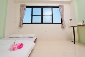 two beds in a room with a window at STSP Guest House in Xinshi