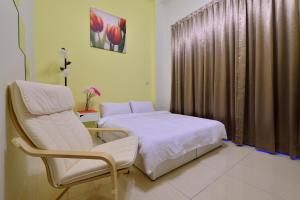 a bedroom with a bed and a chair and a window at STSP Guest House in Xinshi