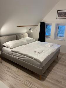 Apartmánový dům Jánský sen في جانسك لازني: غرفة نوم بسرير كبير مع شراشف بيضاء