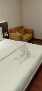 uma cama branca num quarto com um sofá em Hotel JVW Arena em Motīhāri