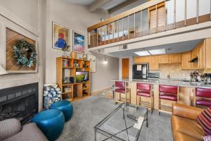 a living room with a kitchen and a fireplace at Powder Pointe A-205 in Park City