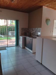 a kitchen with white appliances and a large window at "O Sole Mio" Garden apartment in Bedfordview 12 minutes from OR Tambo International Airport in Bedfordview