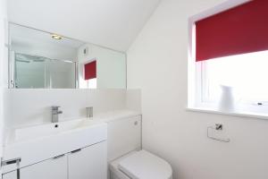a white bathroom with a sink and a mirror at St Ives Bay View in Carbis Bay +13 photos