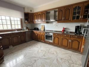 une cuisine avec des armoires en bois et un sol carrelé dans l'établissement Acogedora casa cerca de Marín, à Pontevedra 13 autres photos