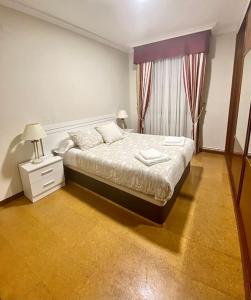une chambre avec un grand lit et une fenêtre dans l'établissement Acogedora casa cerca de Marín, à Pontevedra