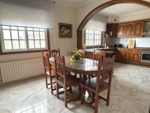 a kitchen with a table and chairs in a room at Acogedora casa cerca de Marín in Pontevedra