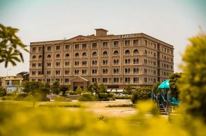 um grande edifício com um parque infantil em frente em Grande Deluxe Luxury Apartment em Rawalpindi