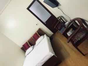 een hotelkamer met een bed en een stoel bij Nhà nghỉ 1061 in Hai Phong