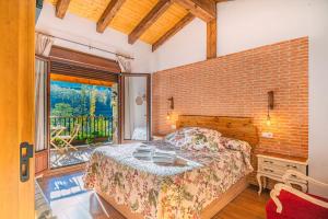 um quarto com uma cama e uma parede de tijolos em Casa Rural La Chopera del Jerte em Jerte