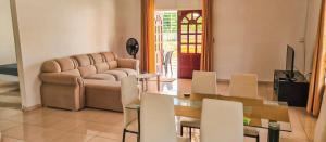 een woonkamer met een bank en een tafel en stoelen bij Kapowlito Real Estate Casa #2 Mon Plaisirweg in Paramaribo