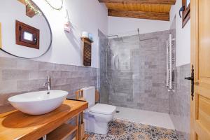 a bathroom with a sink and a toilet and a mirror at Casa Rural La Chopera del Jerte in Jerte