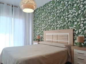 オリーバにあるLujoso apartamento en Olivaの緑の壁、ベッド付きのベッドルーム1室
