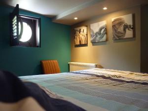 1 dormitorio con 1 cama y algunas fotos en la pared en Boat & Breakfast Bellevue en Gante