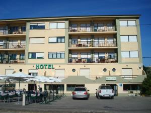 a hotel with cars parked in front of it at Hotel Brisamar in Bañugues