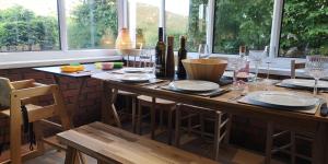 a kitchen with a table with wine bottles and glasses at Hillside Cottage, countryside views near Llangollen in Corwen