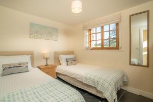 1 dormitorio con 2 camas y ventana en Nant, en Dyffryn