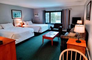 a hotel room with two beds and a living room at Stowe Motel & Snowdrift in Stowe