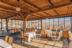Un restaurante con mesas, sillas y ventanas. en Zula Cave House, en Ürgüp