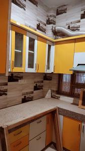 an empty kitchen with yellow and white cabinets at Mishra Guesthouse in Varanasi