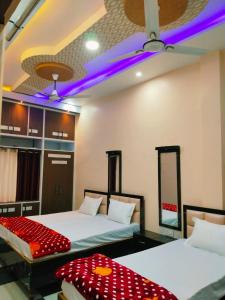 two beds in a room with purple lights at Mishra Guesthouse in Varanasi