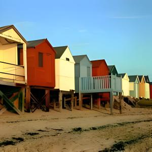 una fila di capanne colorate sulla spiaggia di Victoria House Near Beach With Free Parking a Southend-on-Sea