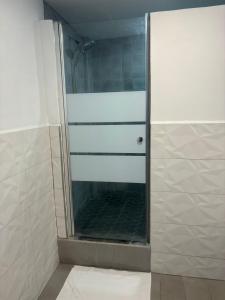 um chuveiro com uma porta de vidro na casa de banho em Villa Maria em Port-of-Spain