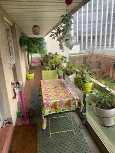 uma varanda com mesa, cadeiras e vasos de plantas em La Vie en Rose-Montparnasse em Paris