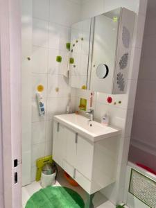 uma casa de banho branca com um lavatório e um espelho em La Vie en Rose-Montparnasse em Paris