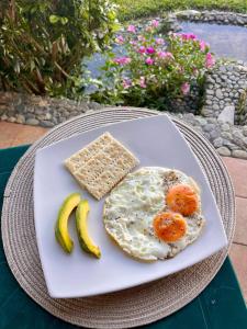 a plate with a fried egg and two bananas at Ventanas Parapente Boutique - Club House in El Cerrito
